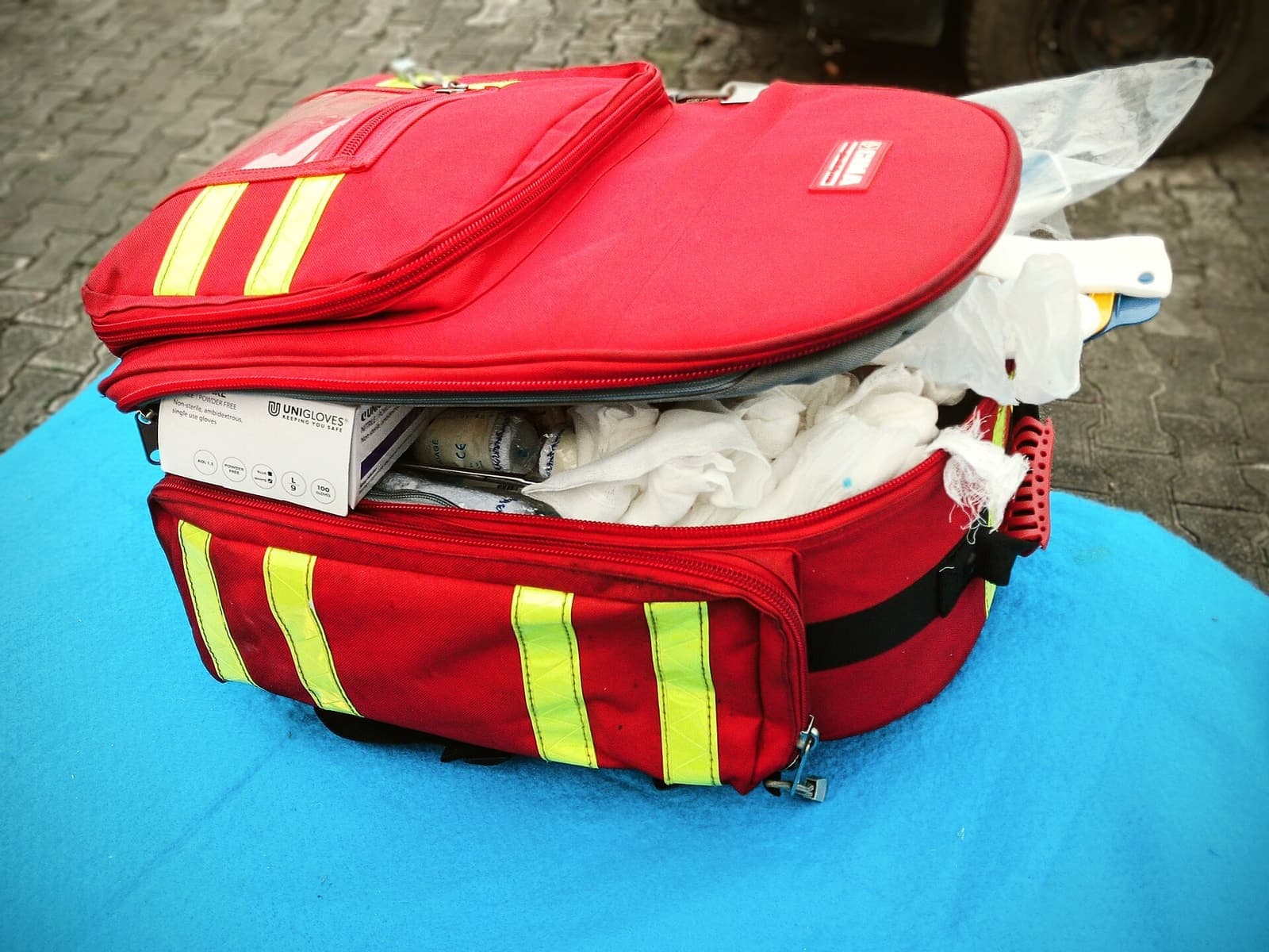 Tas pertolongan pertama merah dengan garis reflektif terbuka di atas meja